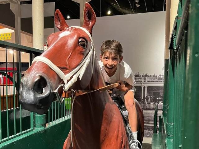Boy rides a horse in an interactive exhibit at the Kentucky Derby Museum
