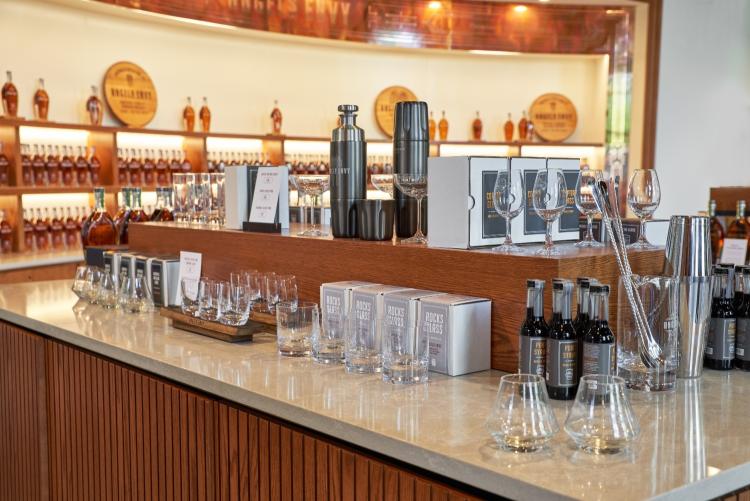 Display shelving with glassware, liquor, and other goods for sale.