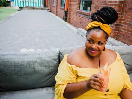 Louisville Guest blogger Andrea Meriwether in yellow dress enjoying cocktail