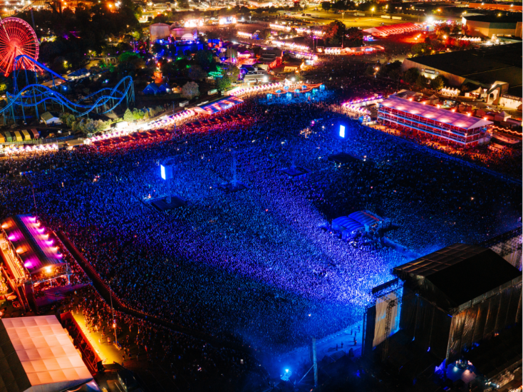 Aerial photo of a massive, blue-lit crowd during the Louder Than Life music festival.
