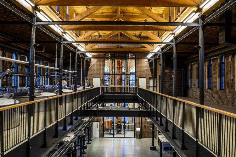 The interior of Angel's Envy Distillery from the top floor looking down into and across a large corridor.
