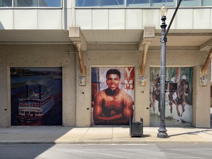 three murals of the Belle of Louisville, Muhammad Ali, and Thoroughbred horses