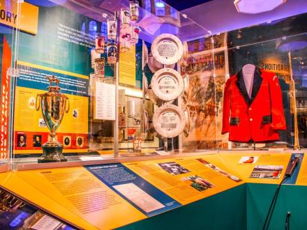 An exhibit displaying trophies and a riding outfit.