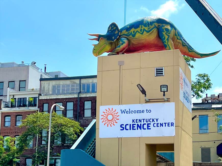 Celebrate Earth Day at Kentucky Science Center a large Triceratops on top of the Kentucky Science Center on Louisville's Main Street