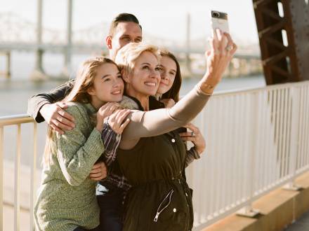a family of four pose for a photo on in Downtown Louisville