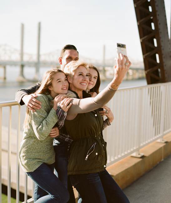 a family of four pose for a photo on in Downtown Louisville