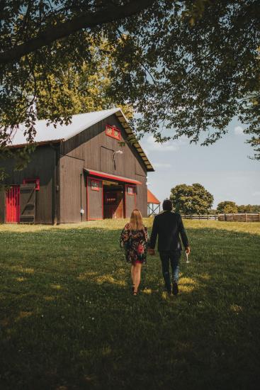 Couple walking up to barn located on Hermitage Farm property in Louisville KY