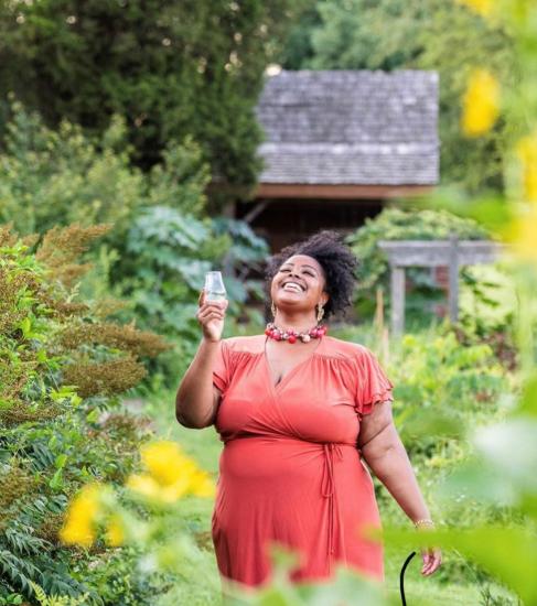 Louisville Guest Blogger Andrea Meriwether walking through greenery while holding a champagne flute