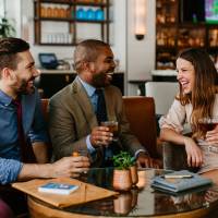 Business looking professionals enjoying a drink of bourbon at Porch Kitchen and Bar in Louisville, Kentucky.