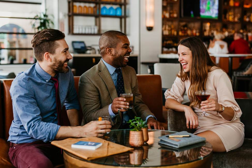 Business looking professionals enjoying a drink of bourbon at Porch Kitchen and Bar in Louisville, Kentucky.